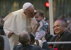 Pope Francis kisses a baby after arriving in Rio de Janeiro July 22, 2013. (CNS photo/Ana Carolina Fernandes, Reuters)