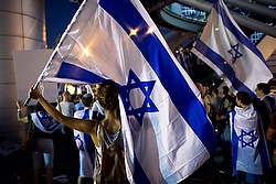 Activists hold flags in Tel Aviv to show support for Israel's offensive in the Gaza Strip
