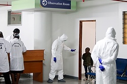 Kenyans from Ebola-hit Liberia arrive home in Kenya A Kenyan Port Health Services worker wearing full personal protective equipment commands a small boy, who is among nine Kenyans who were stranded in the Ebola-hit country Liberia, to return to an observation room for Ebola screening, as they arrive at Jomo Kenyatta International Airport Oct. 28 in Nairobi, Kenya. During his weekly general audience Oct. 29, Pope Francis urged prayers and international action to fight the Ebola virus. (CNS photo/Daniel Irungu, EPA) See POPE-EBOLA Oct. 29, 2014.
