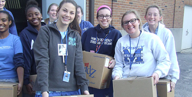 Mercy Mother of Mercy High School Students pose with canned goods collected for the needy. (Courtesy Photo/Mercy High School)