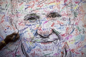 A delegate to the 2015 World Meeting of Families signs a poster drawing of Pope Francis by artist Mark Gaines Sept. 23 in Philadelphia. More than 17,500 participants from more than 100 countries registered for the four-day congress. Those numbers are expected to swell when Pope Francis joins the event Sept. 26-27. (CNS photo/Mark Makela, Reuters)