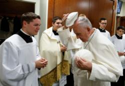 Pope Francis exchanges zucchettos with a server before celebrating Mass with representatives of the Archdiocese of Philadelphia at the Cathedral Basilica of SS. Peter and Paul in Philadelphia Sept. 26. (CNS photo/Paul Haring)
