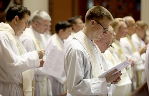 Father Ethan Moore, right, and other priests, sing during the Chrism Mass at the Cathedral of Saint Peter in Chains in Cincinnati Tuesday, March 22, 2016. (CT Photo/E.L. Hubbard)