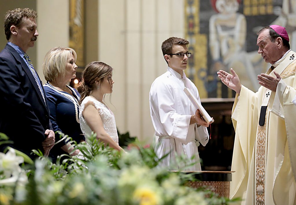Catechumen Alexandra Marie Markley stands with her parents before Archbishop Dennis Schnurr before her baptism for the Easter Vigil in the Holy Night at the Cathedral of Saint Peter in Chains in Cincinnati, Holy Saturday, March 31, 2018. (CT Photo/E.L. Hubbard)