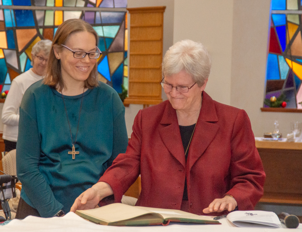 Sister Carol Lichtenberg, Provincial, and Sister Sarah Cieplinski sign the official register of Perpetual Vows, indicating Sarah’s gift of her complete life to God. (Courtesy Photo)